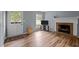 Bright living room with hardwood floors, a cozy fireplace, and a convenient exterior door at 4119 Toroella St, Durham, NC 27704