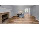 Cozy living room with a brick fireplace, hardwood floors, and ample natural light at 4119 Toroella St, Durham, NC 27704