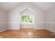 Spacious bedroom with vaulted ceiling and a large window overlooking a green landscape at 4220 Hope Valley Road Rd, Durham, NC 27707