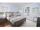 Staged bedroom with hardwood floors, light blue walls and natural light from two windows at 4220 Hope Valley Road Rd, Durham, NC 27707