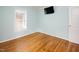 Bedroom featuring hardwood floors, light blue walls, a window, and a mounted television at 4220 Hope Valley Road Rd, Durham, NC 27707