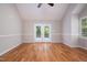 Bright bedroom featuring a vaulted ceiling, hardwood floors, and French doors leading to the backyard at 4220 Hope Valley Road Rd, Durham, NC 27707