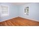 Bright bedroom featuring hardwood floors and two windows offering natural light at 4220 Hope Valley Road Rd, Durham, NC 27707