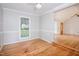 Bright room with hardwood floors, a window with backyard views, and an open doorway at 4220 Hope Valley Road Rd, Durham, NC 27707