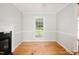 Bright room with a fireplace, hardwood floors, and large windows offering backyard views at 4220 Hope Valley Road Rd, Durham, NC 27707