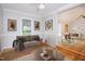 Cozy living room featuring a comfortable sofa, decorative artwork, and natural light at 4220 Hope Valley Road Rd, Durham, NC 27707