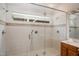 Spacious tile shower featuring a glass enclosure, multiple shower heads, a handheld sprayer, and transom window at 4220 Hope Valley Road Rd, Durham, NC 27707