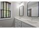 Bright bathroom featuring double sinks, large mirrors, and window with wooden blinds at 450 Granite Mill Blvd, Chapel Hill, NC 27516