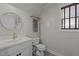 Charming bathroom with a round mirror and a gray towel hanging on a gold colored towel rack at 450 Granite Mill Blvd, Chapel Hill, NC 27516