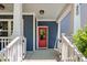 A covered front porch with white pillars, a red door, and house number 450 on a blue house at 450 Granite Mill Blvd, Chapel Hill, NC 27516