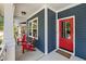 Inviting front porch with blue siding, red front door, and two red chairs at 450 Granite Mill Blvd, Chapel Hill, NC 27516