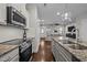 Modern kitchen featuring stainless steel appliances, granite countertops, and an open view to the living room at 450 Granite Mill Blvd, Chapel Hill, NC 27516