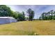 Expansive backyard with outbuildings, a large lawn, and mature trees at 4509 Stevens Chapel Rd, Smithfield, NC 27577