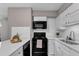 Bright kitchen features white cabinets, subway tile backsplash, and black appliances at 501 Gooseneck Dr # B2, Cary, NC 27513