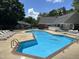 Community pool with lounge chairs and tables; perfect for relaxation and recreation at 501 Gooseneck Dr # B2, Cary, NC 27513
