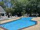Community pool surrounded by lounge chairs, tables, umbrellas and trees at 501 Gooseneck Dr # B2, Cary, NC 27513