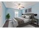 Stylish bedroom featuring a ceiling fan, soft blue walls, and large bed with decorative pillows at 510 Berry Chase Way, Cary, NC 27519