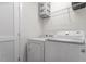 A tidy laundry room with a washer, dryer, storage shelves, and white walls at 510 Berry Chase Way, Cary, NC 27519