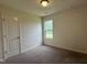 Bedroom with neutral carpet, window, and white door at 5219 Merlin Dr, Snow Camp, NC 27349