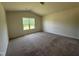 Spacious bedroom with plush carpeting, neutral walls, and a bright window at 5219 Merlin Dr, Snow Camp, NC 27349