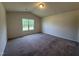 Spacious bedroom with plush carpeting, neutral walls, and a bright window at 5219 Merlin Dr, Snow Camp, NC 27349