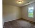 Bedroom with neutral carpet, window, and white door at 5219 Merlin Dr, Snow Camp, NC 27349