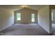 Bright living room with plush carpeting, large windows and vaulted ceiling at 5219 Merlin Dr, Snow Camp, NC 27349