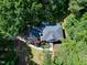Aerial view of a home with a dark roof, surrounded by lush, mature trees in a private backyard setting at 5304 W Oaks Dr, Fuquay Varina, NC 27526