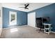 Bedroom features neutral carpet and bright blue walls and a fan with bright light at 5304 W Oaks Dr, Fuquay Varina, NC 27526