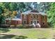 Traditional brick home with a landscaped front yard and inviting entrance with charming front lawn and mature trees at 5304 W Oaks Dr, Fuquay Varina, NC 27526