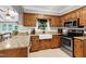 Kitchen with wooden cabinets, granite countertops, stainless steel appliances, and a farm sink at 5304 W Oaks Dr, Fuquay Varina, NC 27526