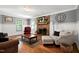 Inviting living room with a brick fireplace, hardwood floors, and a neutral color scheme with comfy furniture at 5304 W Oaks Dr, Fuquay Varina, NC 27526
