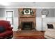 Cozy living room featuring a brick fireplace, wood floors, and comfortable seating furniture at 5304 W Oaks Dr, Fuquay Varina, NC 27526