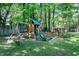 Backyard playground equipment among the trees providing a playful outdoor space for children in a serene setting at 5304 W Oaks Dr, Fuquay Varina, NC 27526