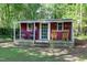 Outbuilding featuring rocking chairs on the porch and unique décor, offering extra space or potential workshop at 5304 W Oaks Dr, Fuquay Varina, NC 27526