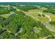Aerial view of property with lush greenery, a pond, and swimming pool at 5520 Creek Pine Dr, Wake Forest, NC 27587