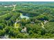 Aerial view of property showcasing the pond, lush greenery, and serene neighborhood at 5520 Creek Pine Dr, Wake Forest, NC 27587