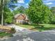 Charming two-story home with stone accents, well-manicured lawn, mature trees, and paved driveway at 5520 Creek Pine Dr, Wake Forest, NC 27587