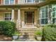 Elegant front entrance with stone pillars, a wood door, and decorative planters at 5520 Creek Pine Dr, Wake Forest, NC 27587