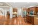 Open-concept kitchen with rich cabinetry, hardwood floors, stainless appliances, and granite counters at 5520 Creek Pine Dr, Wake Forest, NC 27587