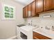 Functional laundry room with washer, dryer, sink, and ample cabinet storage at 5520 Creek Pine Dr, Wake Forest, NC 27587