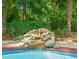 Backyard pool featuring a rock waterfall and a well-manicured garden and landscaping at 5520 Creek Pine Dr, Wake Forest, NC 27587