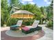 Outdoor lounging area with patio furniture and an umbrella, near manicured landscaping at 5520 Creek Pine Dr, Wake Forest, NC 27587