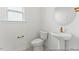 Neat half bath featuring a pedestal sink, sleek toilet, and simple design with gold fixtures at 56 Mable Court # 20, Lillington, NC 27546