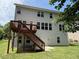 View of the back of the home including the yard, deck and multiple windows at 5804 Claribel Ct, Raleigh, NC 27612