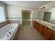 Bright bathroom features a large soaking tub, double vanity, and tiled floors at 5804 Claribel Ct, Raleigh, NC 27612