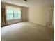 Spacious bedroom with large window allowing natural light and neutral carpeting at 5804 Claribel Ct, Raleigh, NC 27612