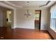 Bright dining room with hardwood floors, decorative chandelier, and views into the living spaces at 5804 Claribel Ct, Raleigh, NC 27612