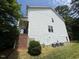 Two-story home's side view with white siding, brick foundation, and air conditioning units at 5804 Claribel Ct, Raleigh, NC 27612