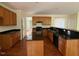 Kitchen features wood cabinets, an island with bar seating, and black countertops at 5804 Claribel Ct, Raleigh, NC 27612